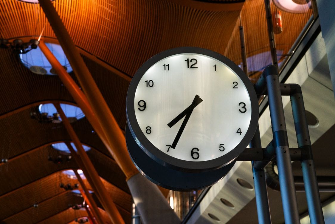 A large terminal clock: bag drop deadlines are fixed to your scheduled departure time, not the actual one