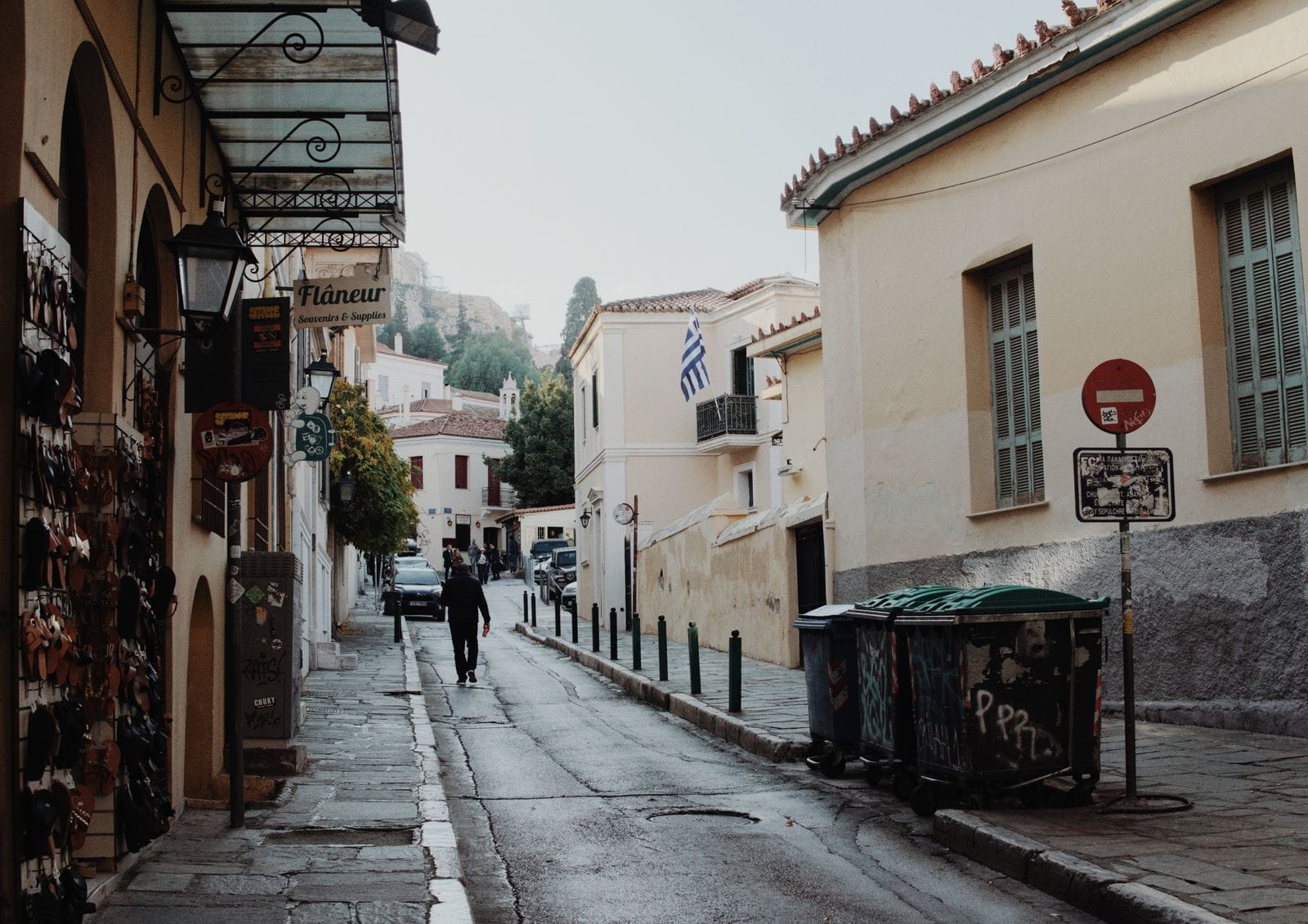 A quiet street in Athens' Plaka district, lined with Greek flags and free to wander