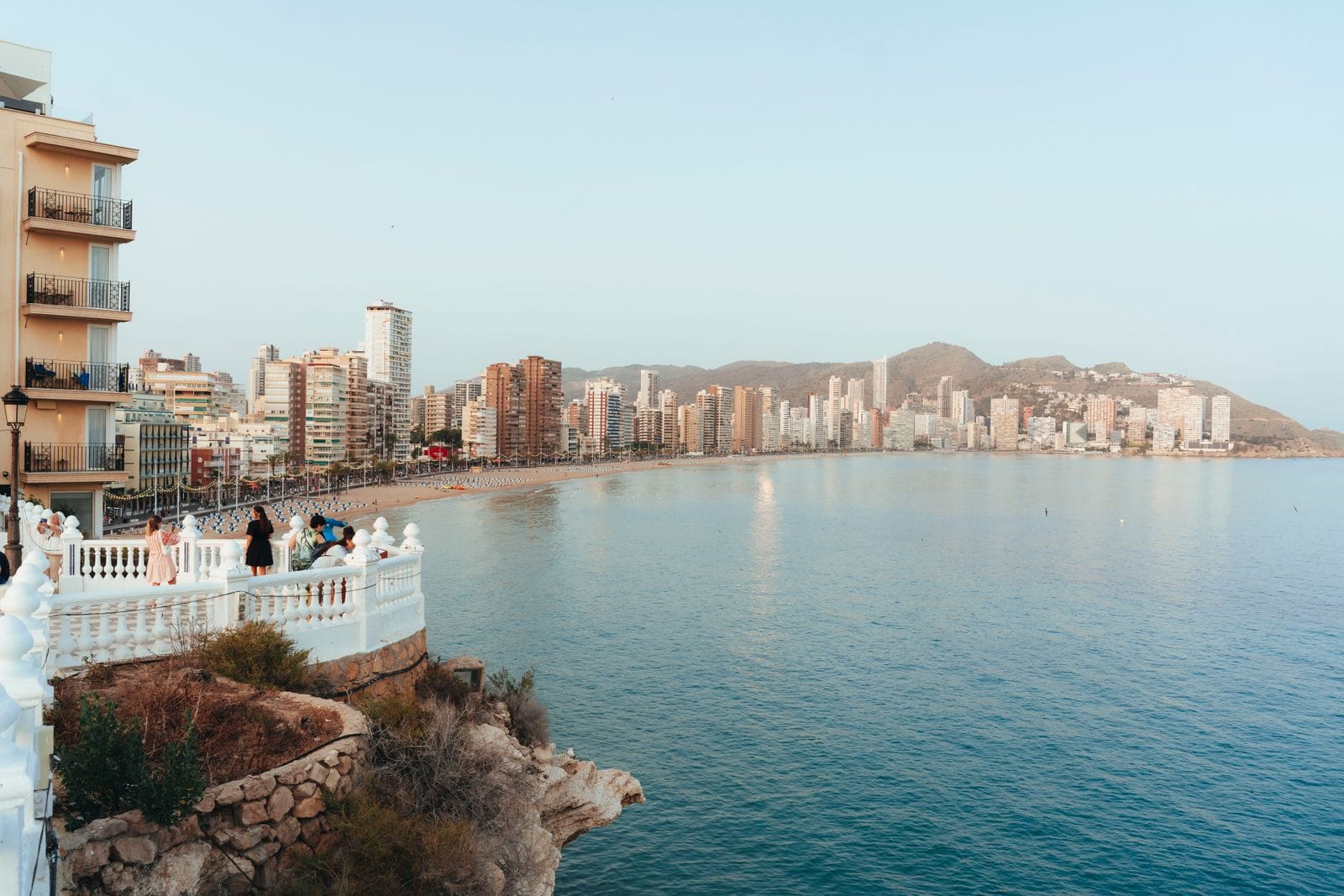 The white balustrade of Benidorm's Balcon del Mediterraneo viewpoint, with the curve of Levante beach and the city's towers behind