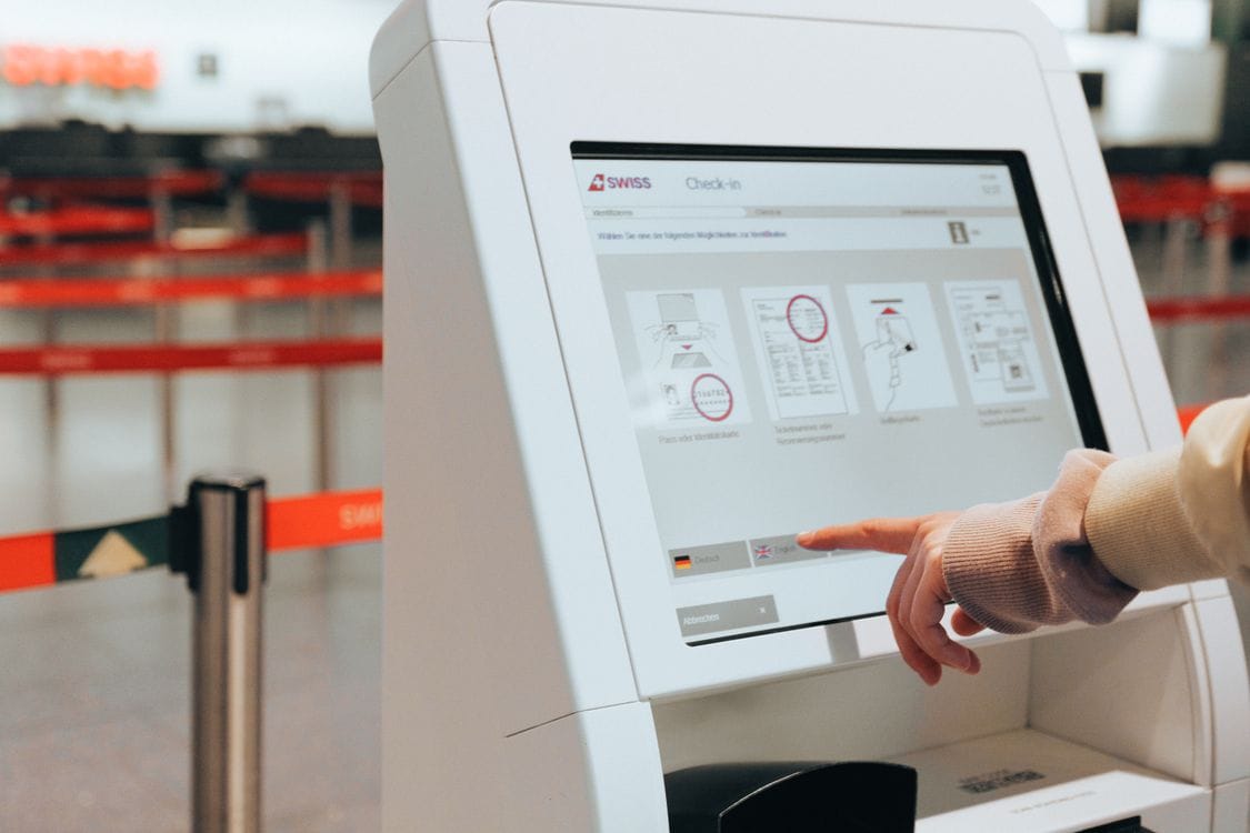 A passenger using a self-service check-in kiosk at the airport