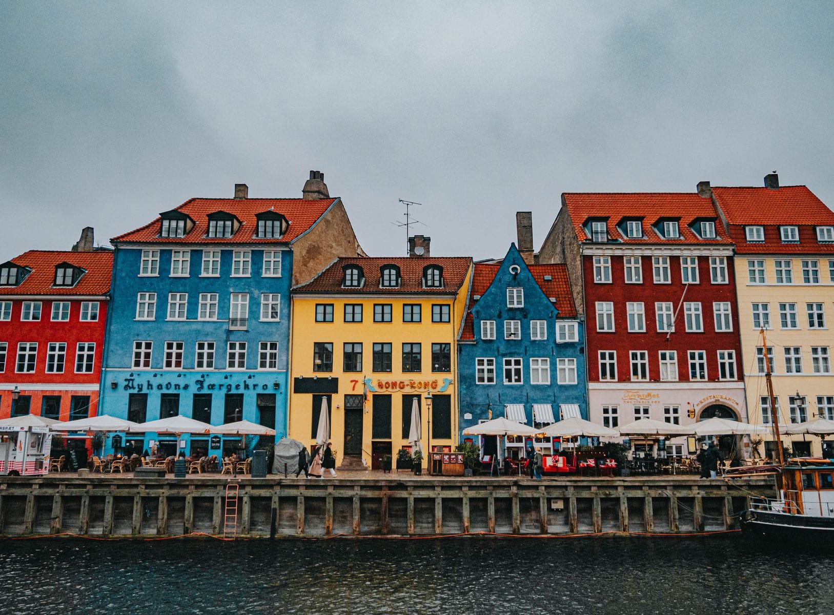 Is Copenhagen expensive: Nyhavn's colourful 17th-century harbourfront houses on an overcast day