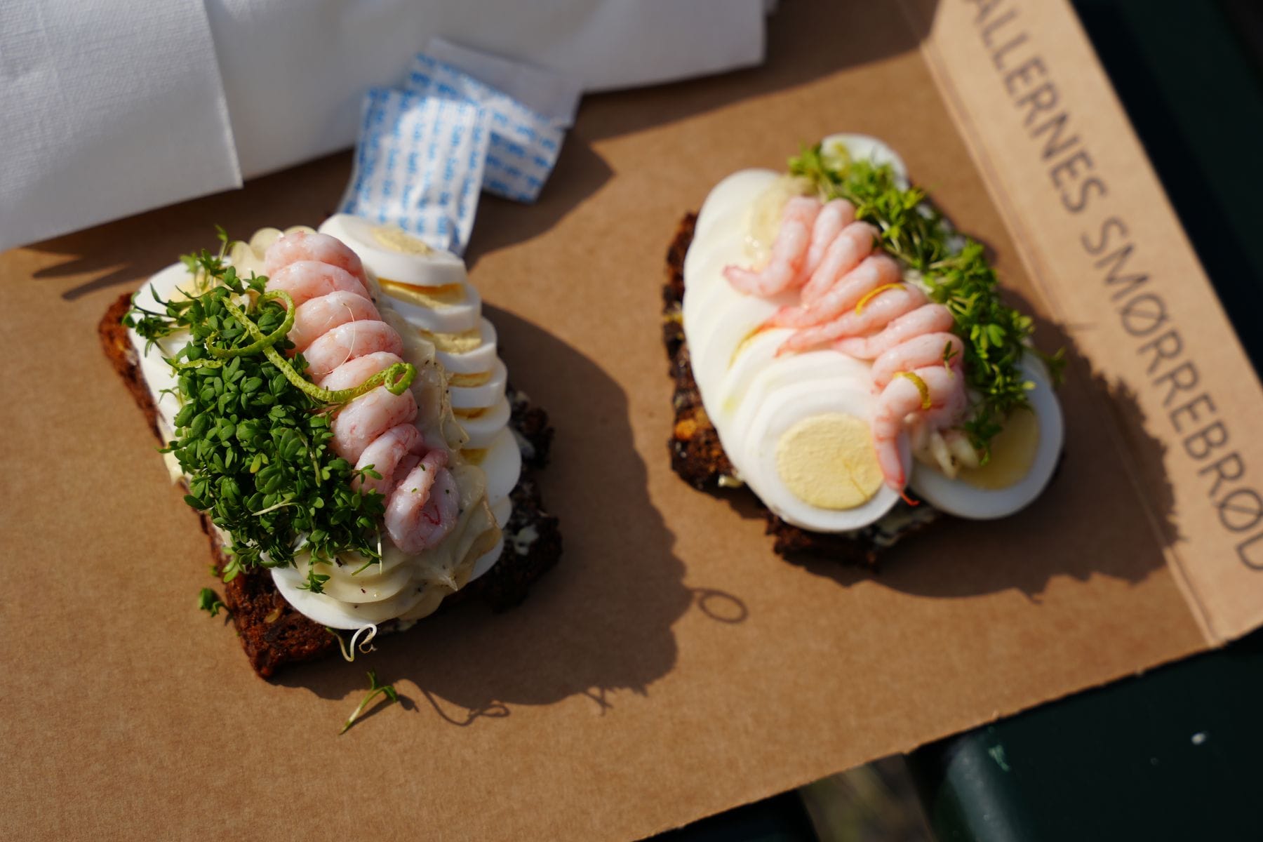 Traditional Danish smorrebrod open sandwiches topped with prawns and egg on rye bread