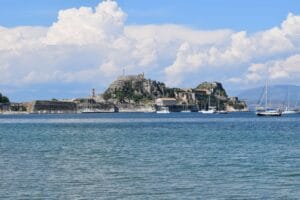 Is Corfu expensive: the Old Fortress of Corfu on its headland across the water, with sailing boats moored in front