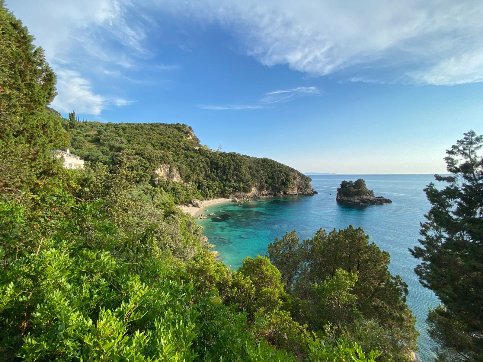 A turquoise cove at Paleokastritsa on Corfu, framed by steep green hillsides