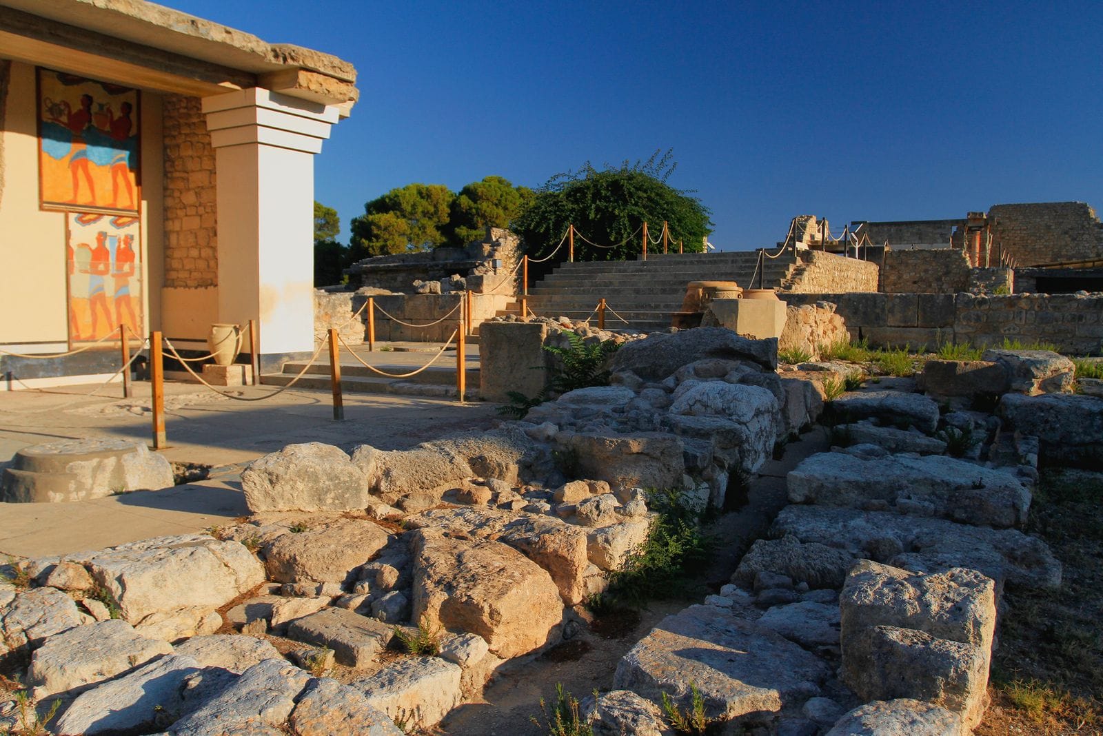 Stone ruins and a reconstructed Minoan fresco wall at the Palace of Knossos near Heraklion