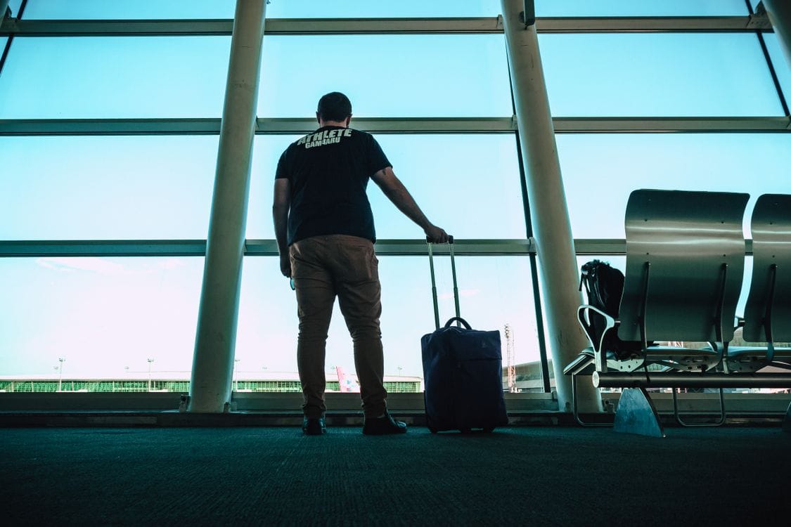 A man waiting with luggage at an airport lounge