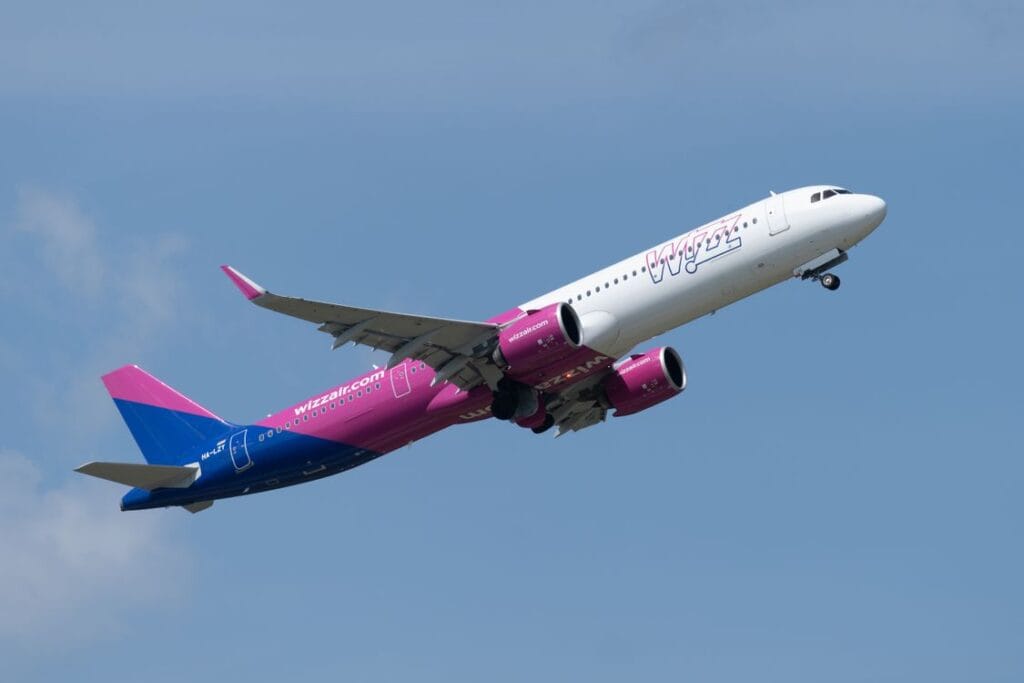 Is Wizz Air travel insurance worth it? A Wizz Air Airbus A321 climbing into a blue sky after departure
