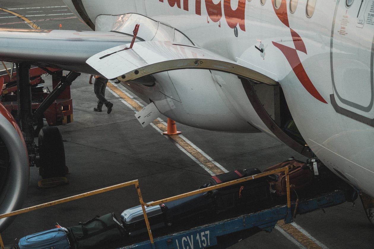 Suitcases riding a belt loader into an aircraft hold, where Jet2 checked baggage travels