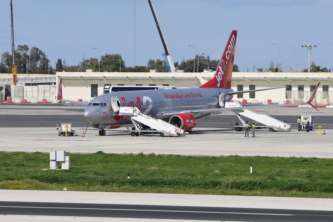 A Jet2 aircraft on the tarmac with passenger boarding stairs in place