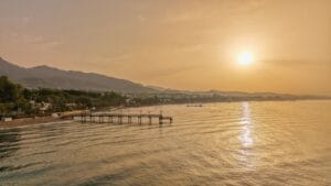 Marbella on a budget: sunset over Marbella coastline and pier on the Costa del Sol