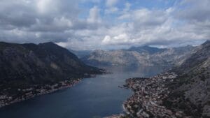 Is Montenegro expensive: an aerial view down the Bay of Kotor, with the town strung along the shoreline and mountains falling to the water on both sides