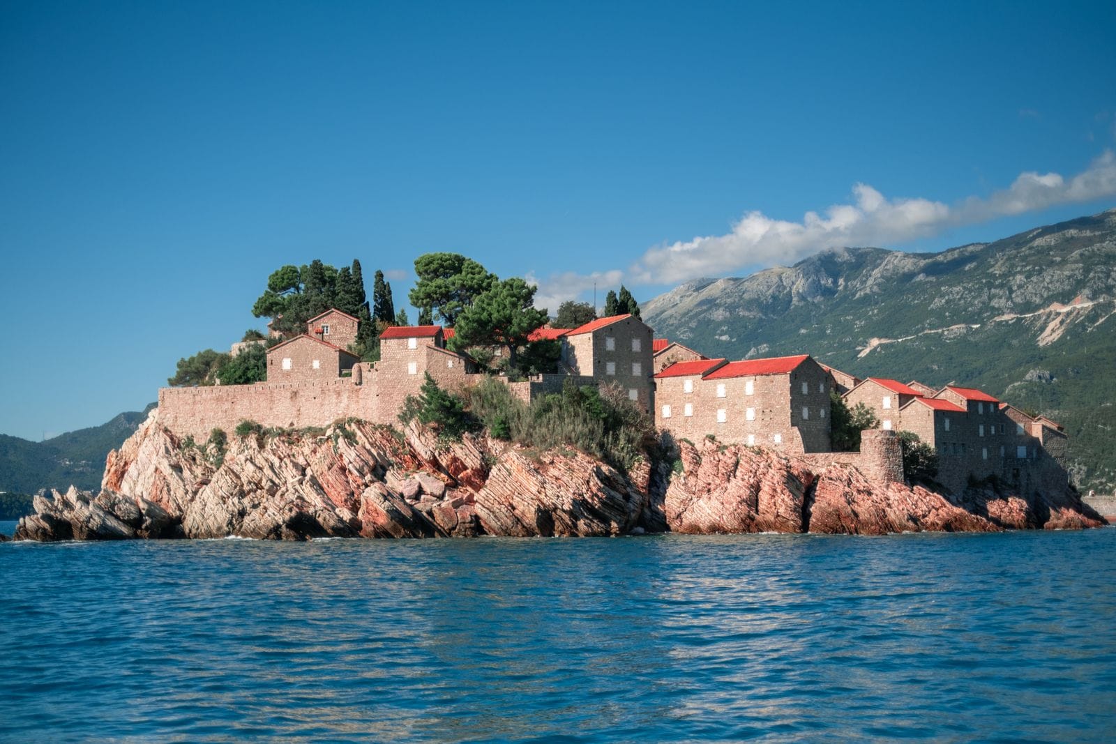 The island of Sveti Stefan with its red-roofed stone village rising from the sea, joined to the mainland by a narrow causeway