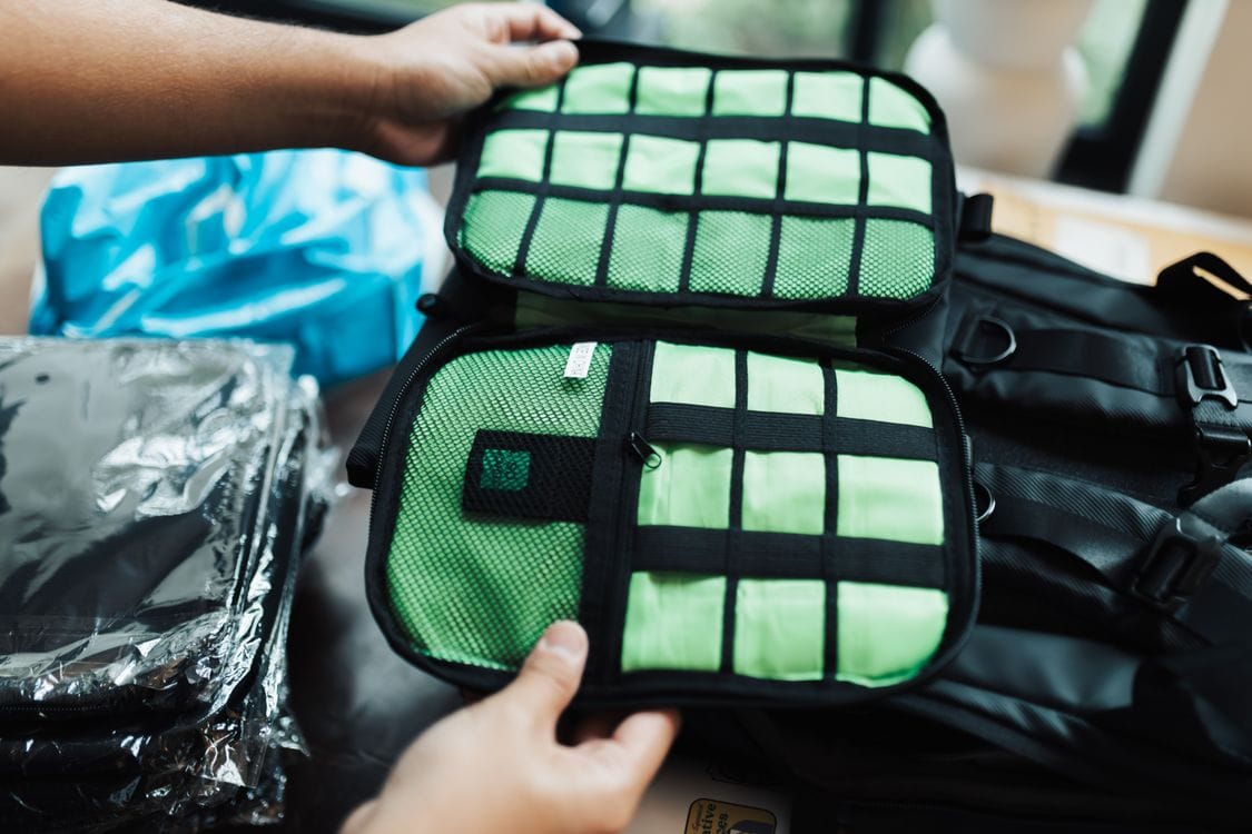 Hands organising a suitcase with packing cubes, useful for fitting bags to the Virgin Atlantic carry on limit