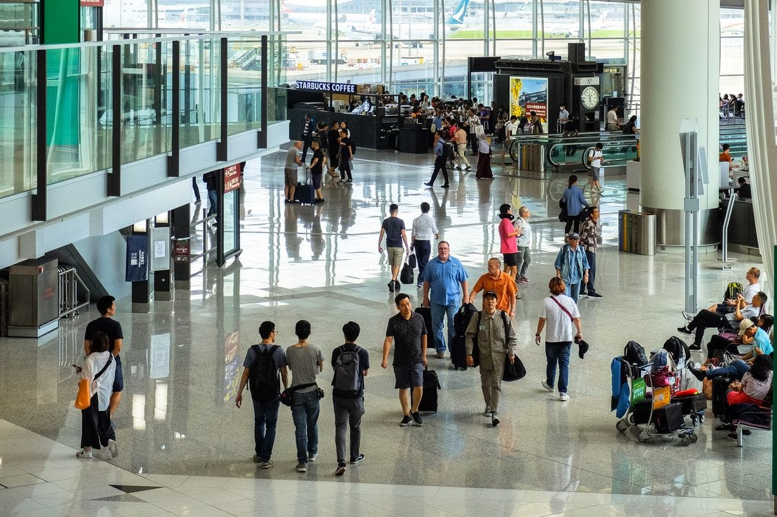 Airport terminal busy with travellers deciding whether to pay the fee or book a fresh flight