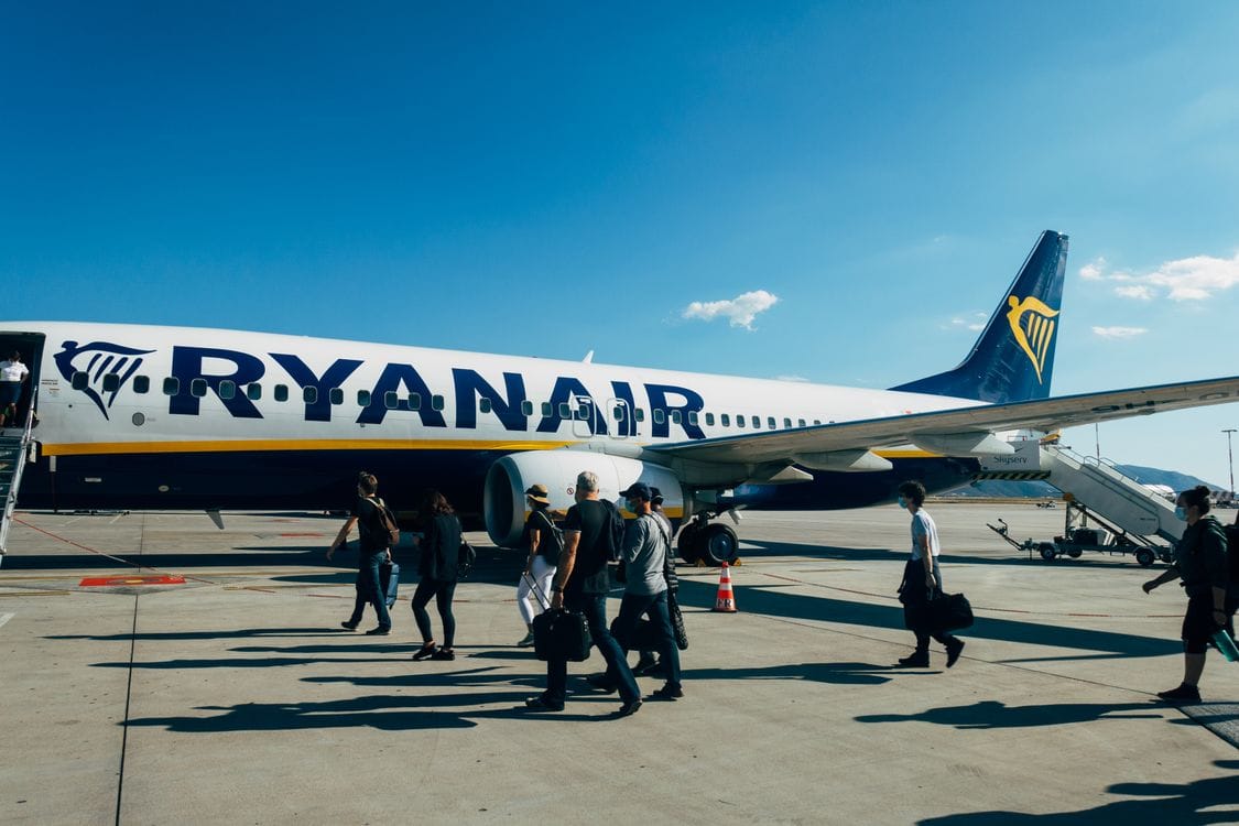 Travellers boarding a Ryanair aircraft under a clear blue sky: Ryanair Priority Boarding puts you in this queue first