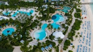 Aerial view of a Caribbean beachfront resort with pools and palm trees