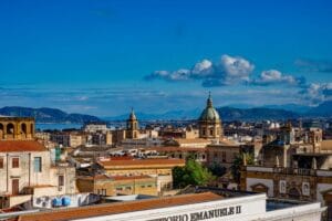 Is Sicily expensive: Palermo's skyline, domed churches and rooftops beneath a clear blue sky