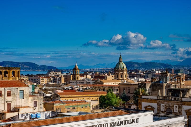 Is Sicily expensive: Palermo's skyline, domed churches and rooftops beneath a clear blue sky