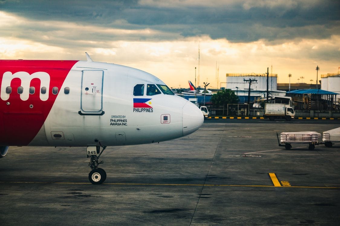 A passenger airplane on the tarmac under a stormy sky