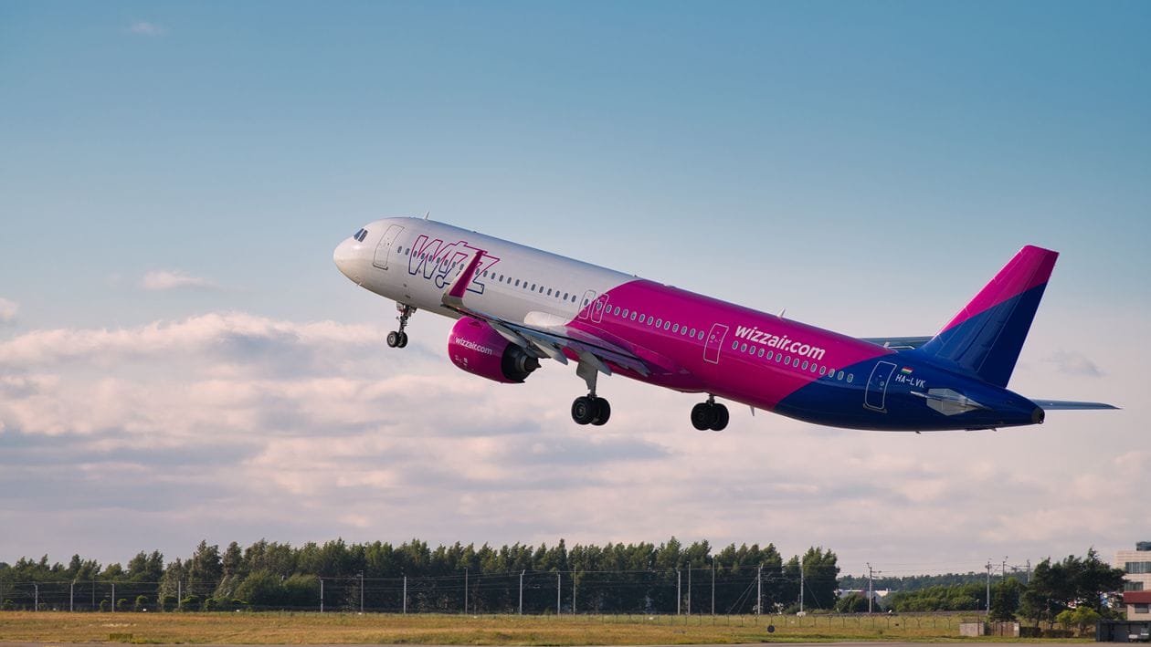 A Wizz Air Airbus A320 ascending into a clear sky shortly after take-off