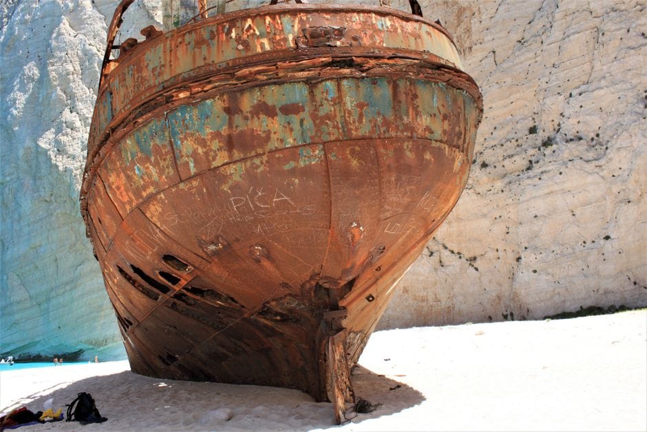 The rusting shipwreck at Navagio Beach seen close up against pale cliffs