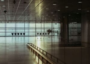 Is airport fast track worth it: an empty, glass-walled airport terminal with the runway beyond
