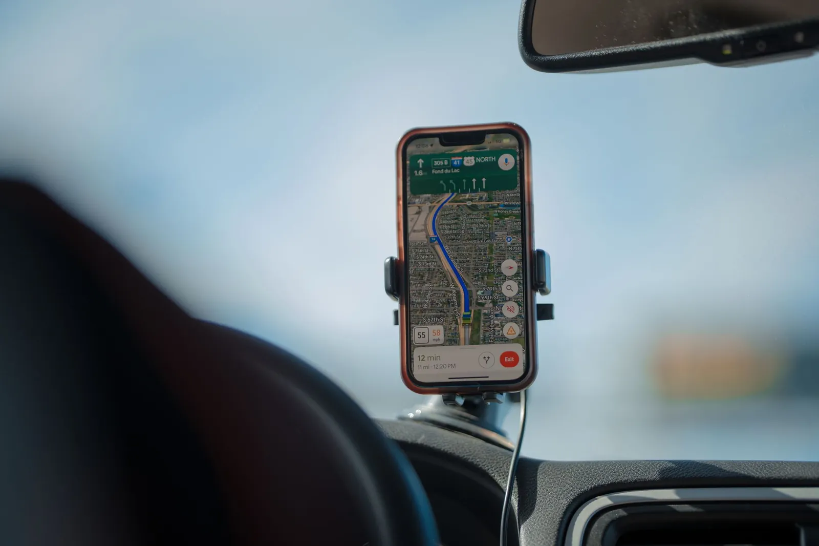 A smartphone running a navigation app, mounted on a car dashboard