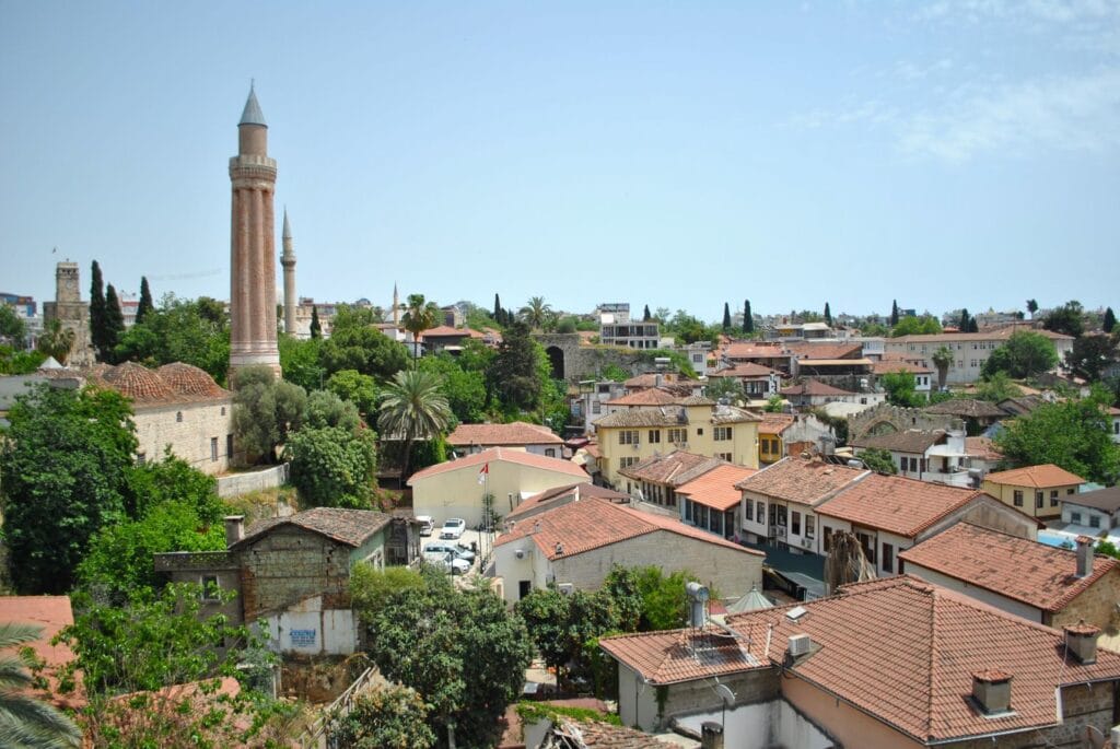 Is Antalya expensive: aerial view of Kaleici's terracotta rooftops in Antalya old town, with the fluted Yivli Minare rising above the trees