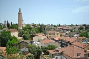 Is Antalya expensive: aerial view of Kaleici's terracotta rooftops in Antalya old town, with the fluted Yivli Minare rising above the trees