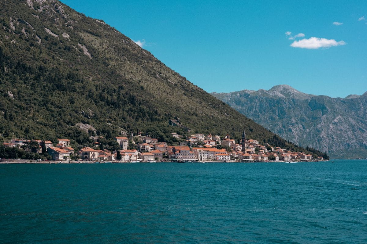 A small town on the shore of the Bay of Kotor in Montenegro, below steep mountains