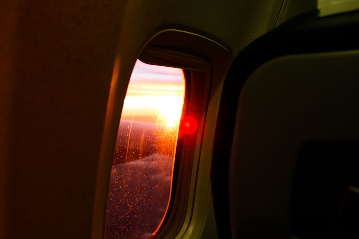 Sunset light through an aircraft window during a flight