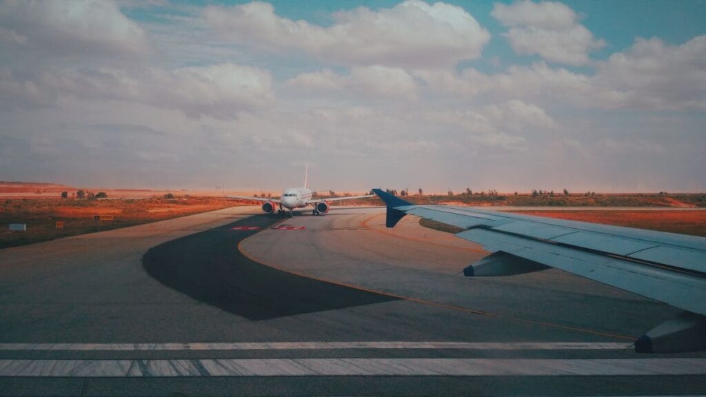An aircraft taxiing to the runway at golden hour, seen from a window seat
