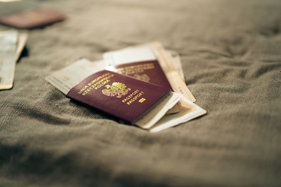 A passport and travel documents on a bed