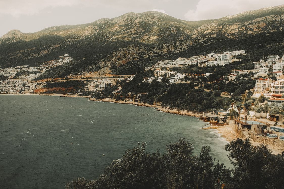 A Mediterranean coastal town seen from the hillside above, the kind of trip travel insurance is bought to protect