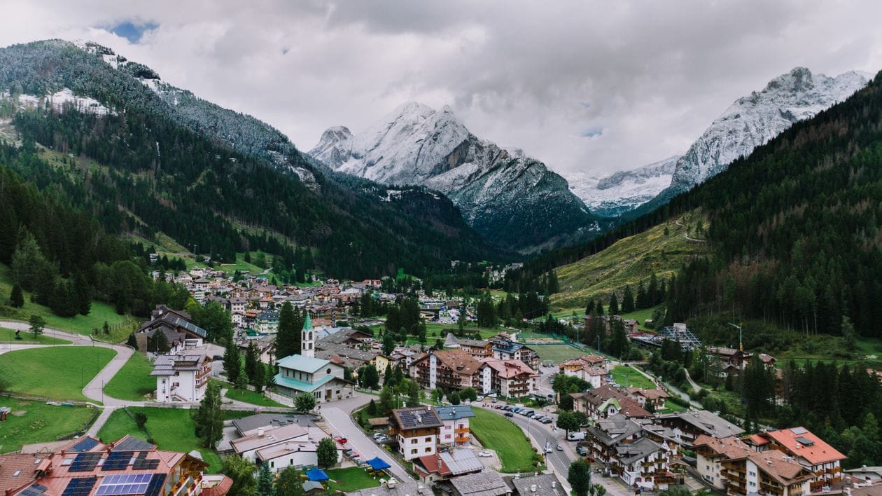 An aerial view of an Alpine village nestled in the Dolomites mountains
