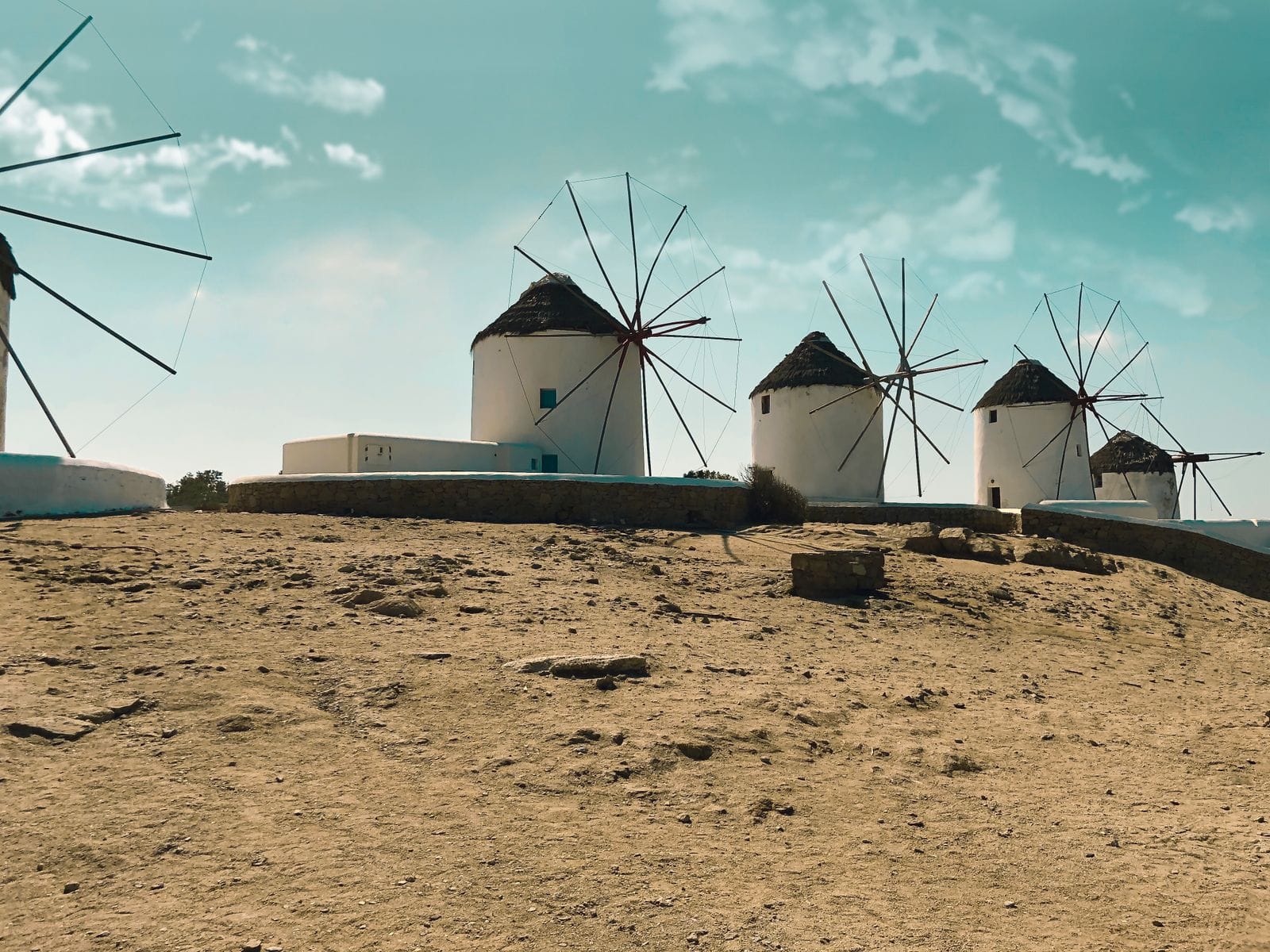 The row of white Kato Mili windmills on the hill above Mykonos Town, under a bright blue sky