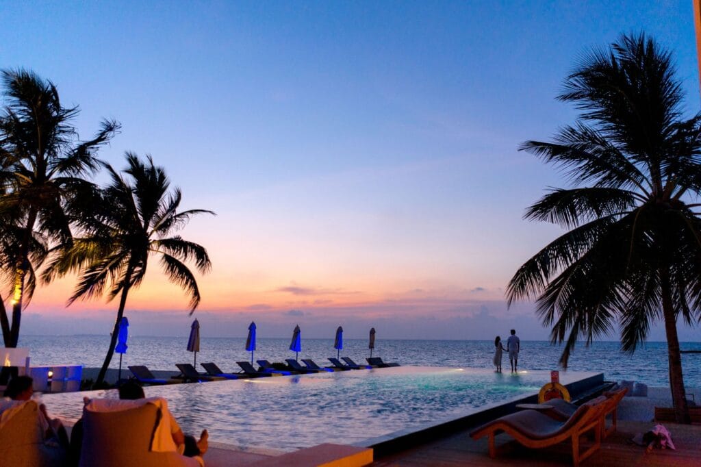 Couple watching the sunset by an infinity pool at a Caribbean resort