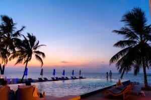 Couple watching the sunset by an infinity pool at a Caribbean resort