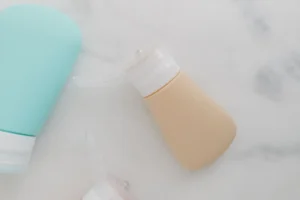 Wizz Air liquid rules: squeezable travel bottles with flip-top caps on a marble surface
