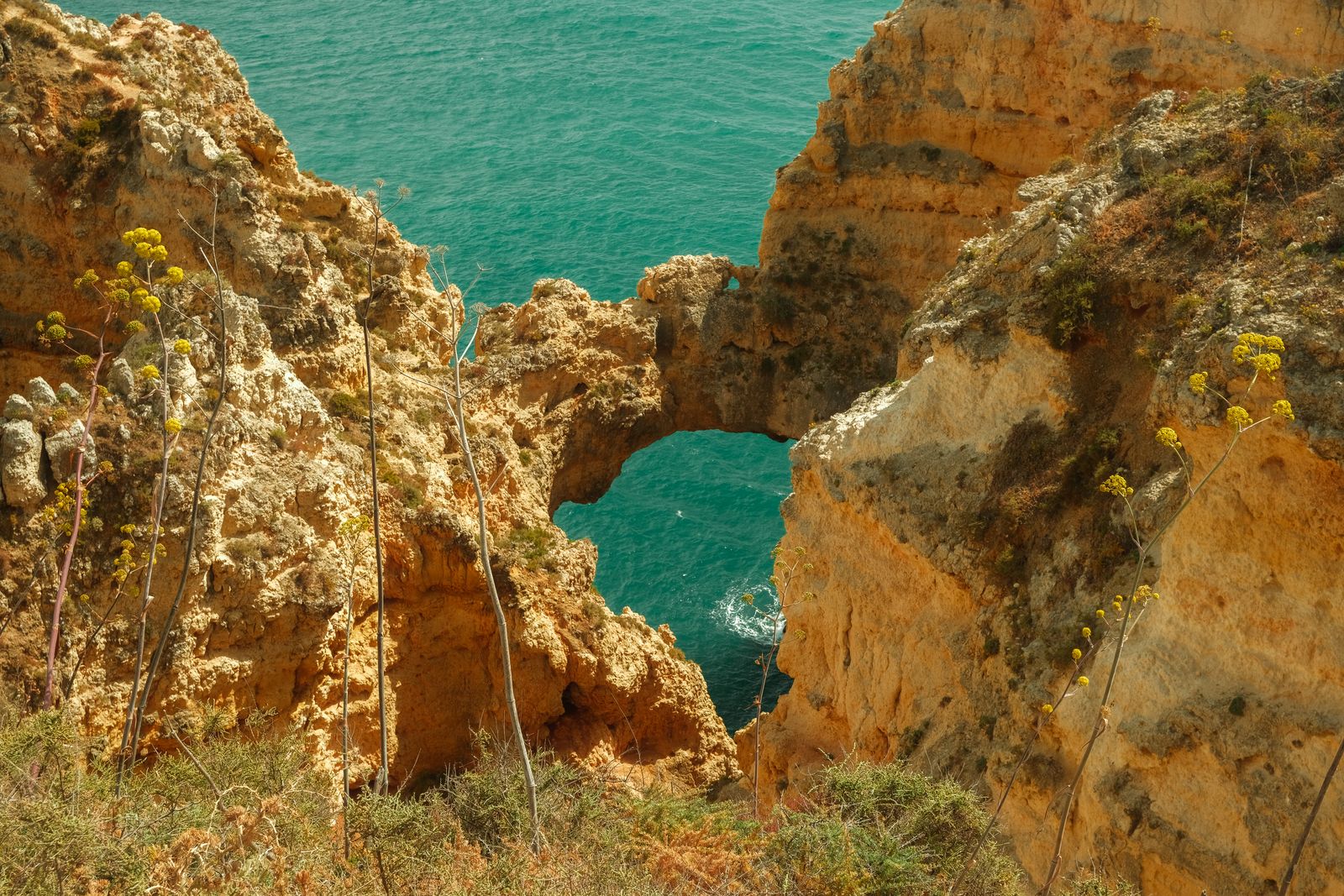 Golden cliffs and a rock arch above turquoise sea at Ponta da Piedade, on the Algarve coast covered by the Wowcher Algarve deal