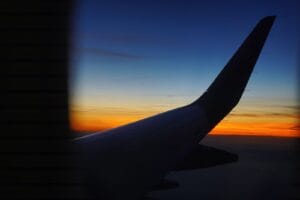 Black Friday flight deals: an aircraft wing silhouetted against a blue and orange sunset sky