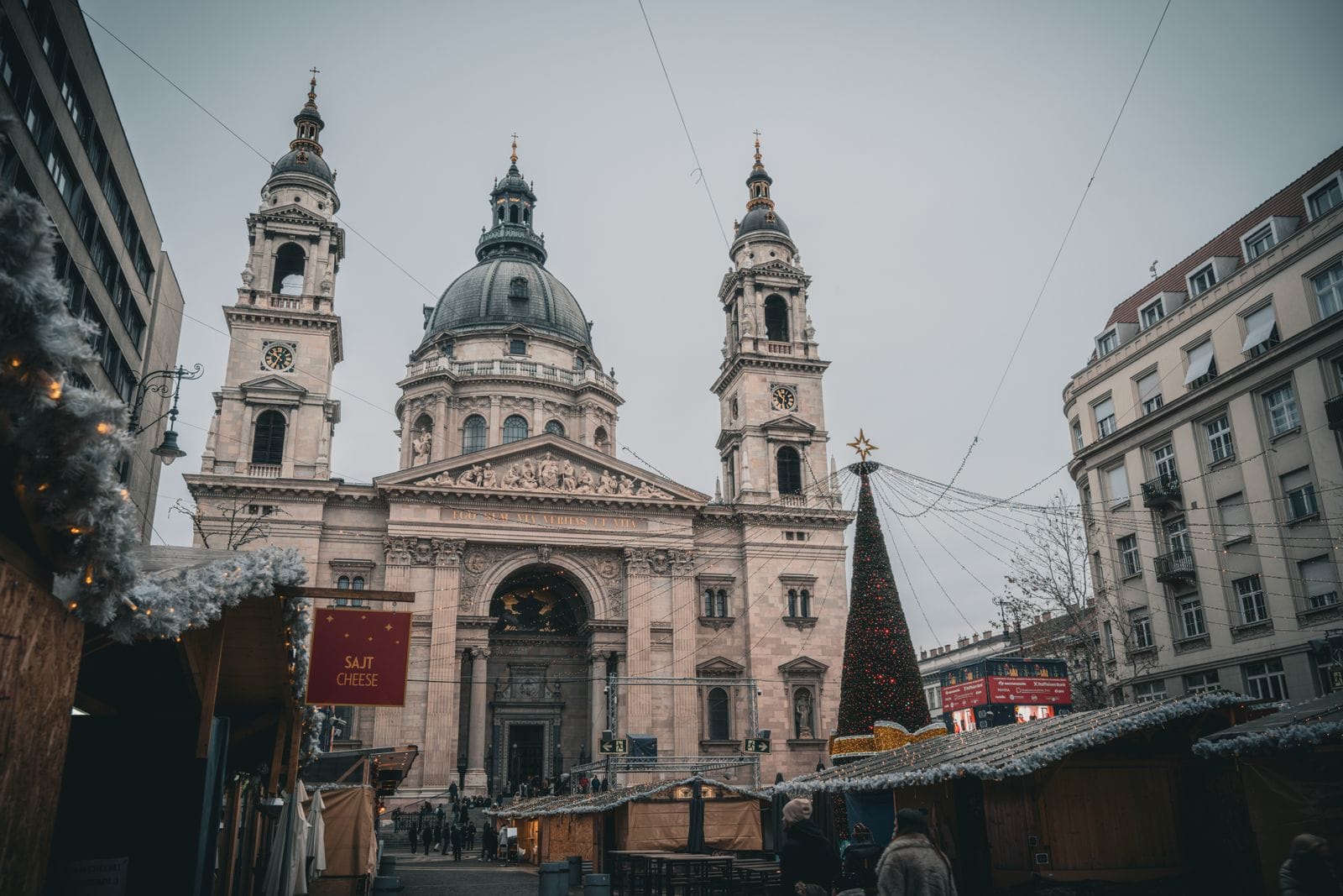 Wooden Christmas market stalls and a lit Christmas tree in front of St Stephen's Basilica in Budapest