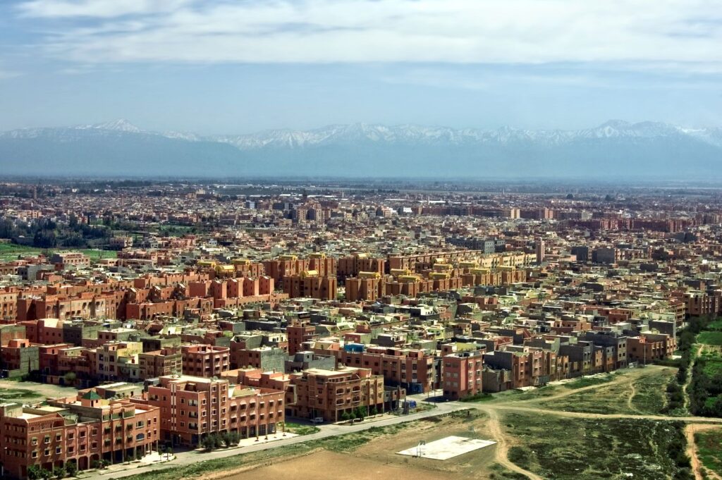 Budget travel destinations: terracotta Marrakech from above, with the snow-capped Atlas Mountains behind