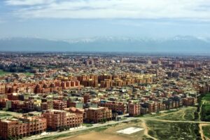 Budget travel destinations: terracotta Marrakech from above, with the snow-capped Atlas Mountains behind