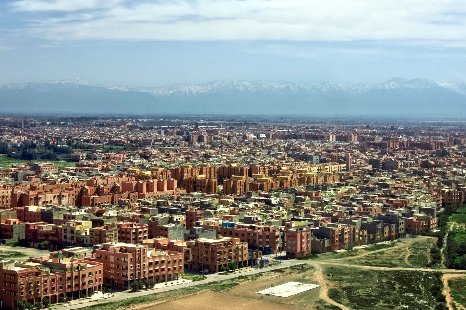 Budget travel destinations: terracotta Marrakech from above, with the snow-capped Atlas Mountains behind