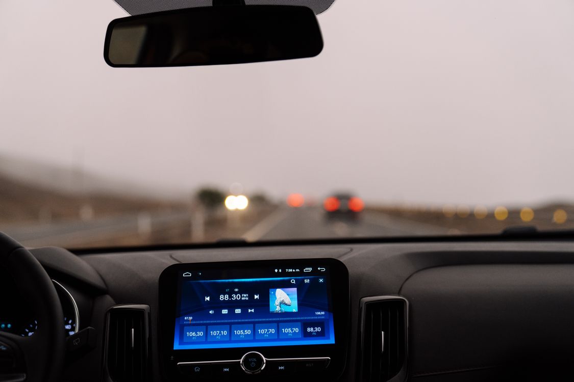 A hire car dashboard on a motorway in haze, where a chipped windscreen or scraped bumper can leave you paying the excess
