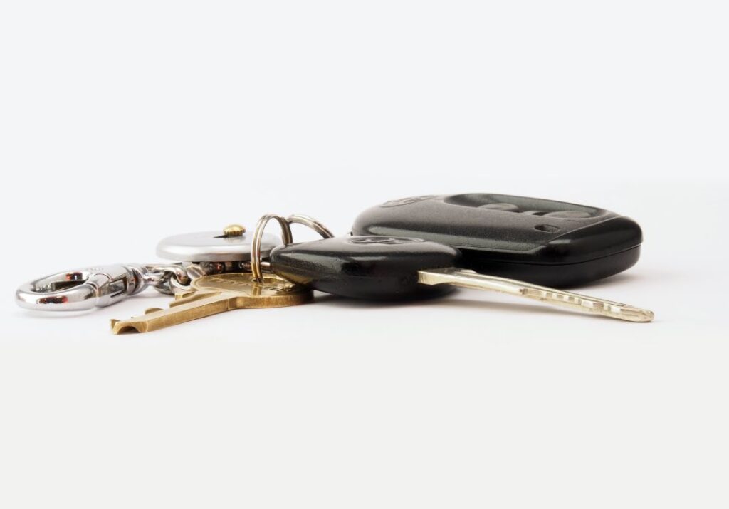 Car keys and a fob on a white surface: car hire excess insurance repays what you owe if the hire car is damaged