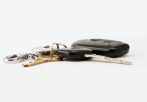 Car keys and a fob on a white surface: car hire excess insurance repays what you owe if the hire car is damaged