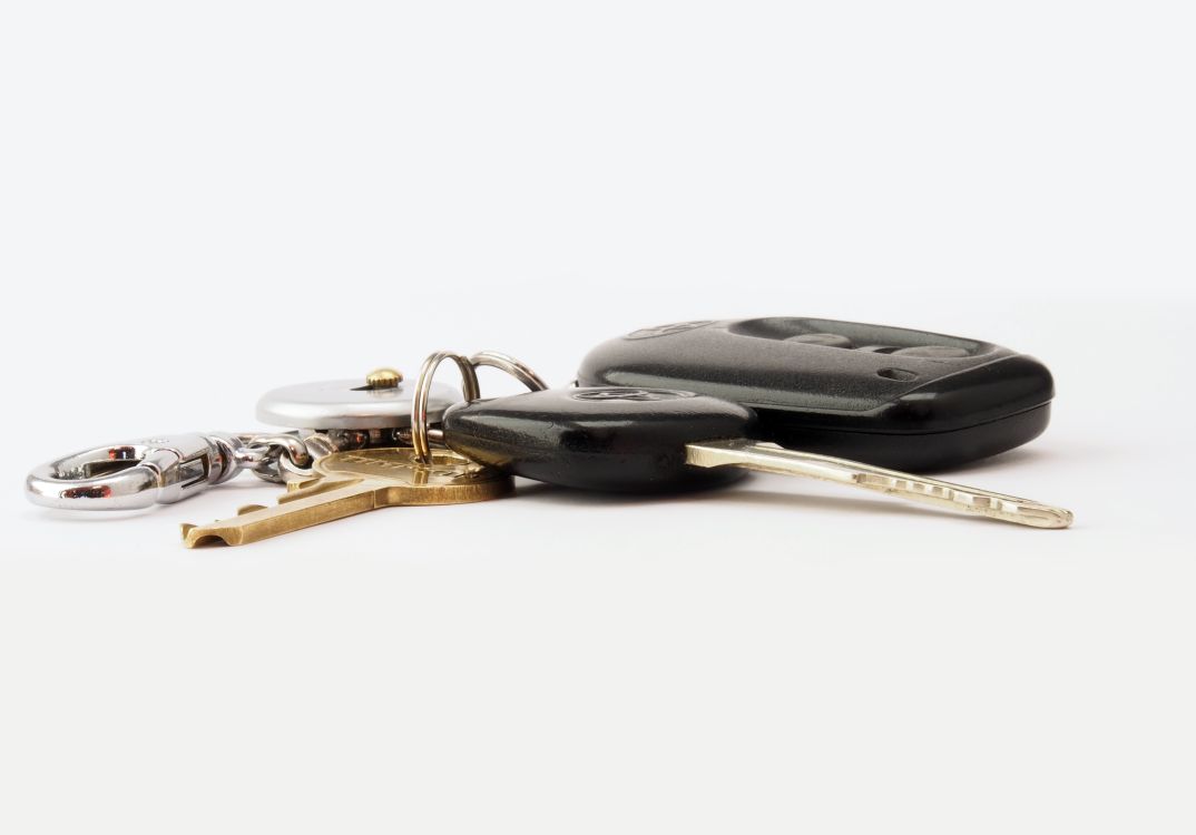 Car keys and a fob on a white surface: car hire excess insurance repays what you owe if the hire car is damaged