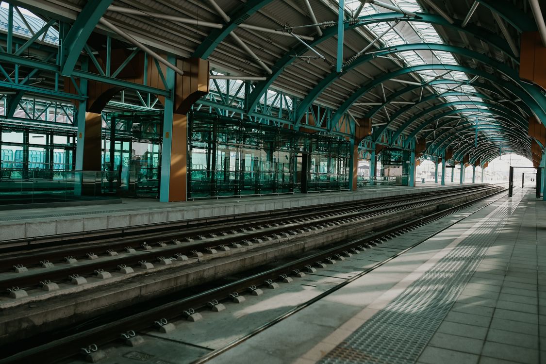 An empty railway platform under a curved steel and glass roof, as at the train station serving Gatwick Airport terminals